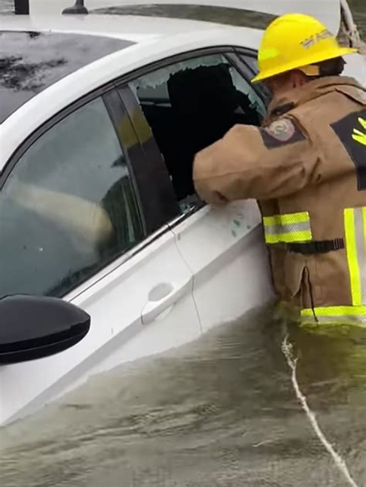 
Hurricane Ian Flood Waters Leave Fla. Driver Stranded: See Rescue Workers Pull Woman from Her Car 